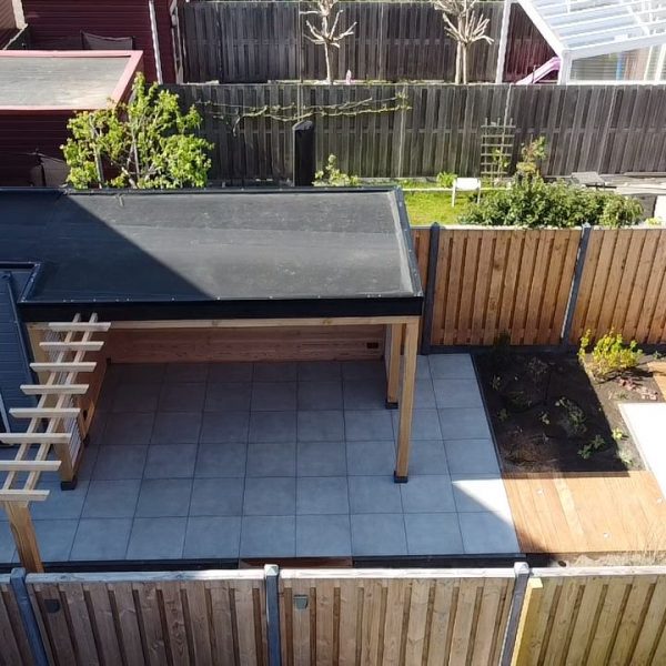 Achtertuin van bovenaf met hekwerk en bestrating